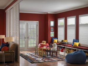Sliding plantation shutter panels in red room with window blinds